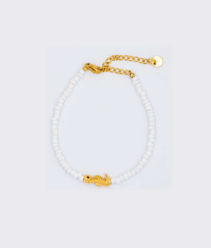 Witte kralen armband met een zeepaardje als bedel en gouden stainless steel sluiting